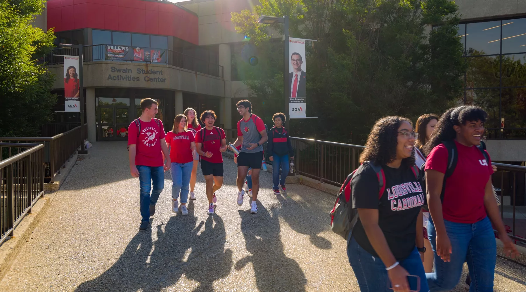 A group of students exiting the Student Activities Center on a sunny morning