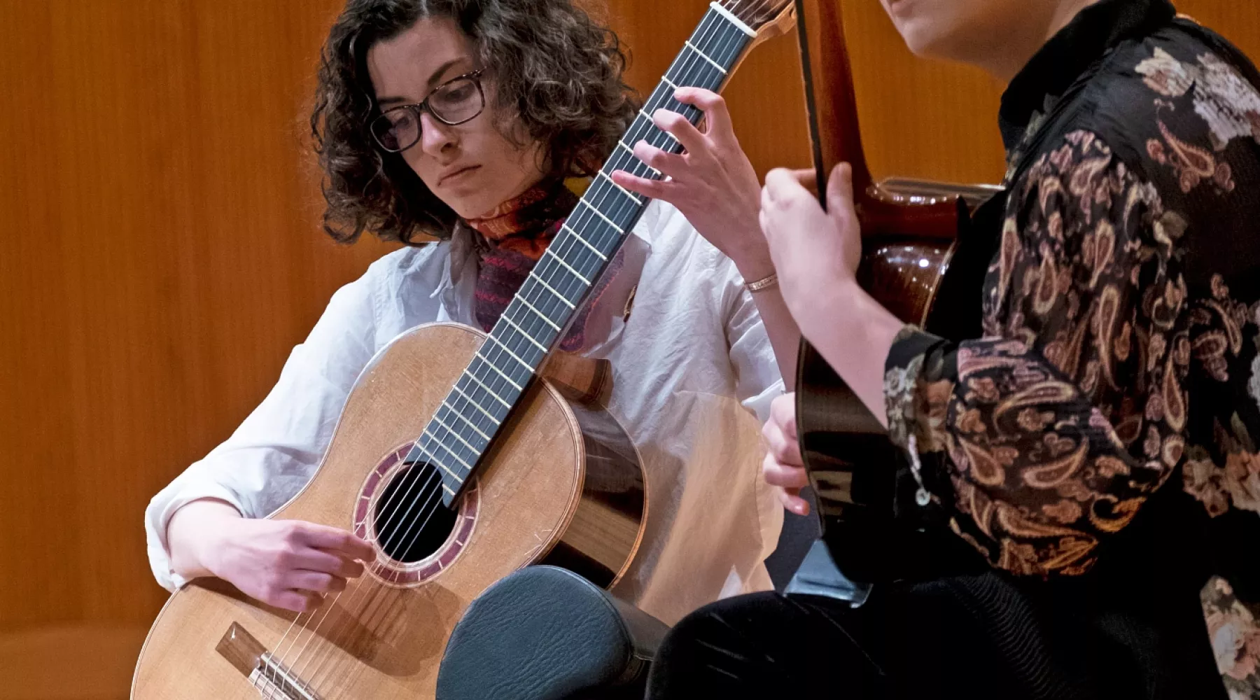 Two woman play guitar
