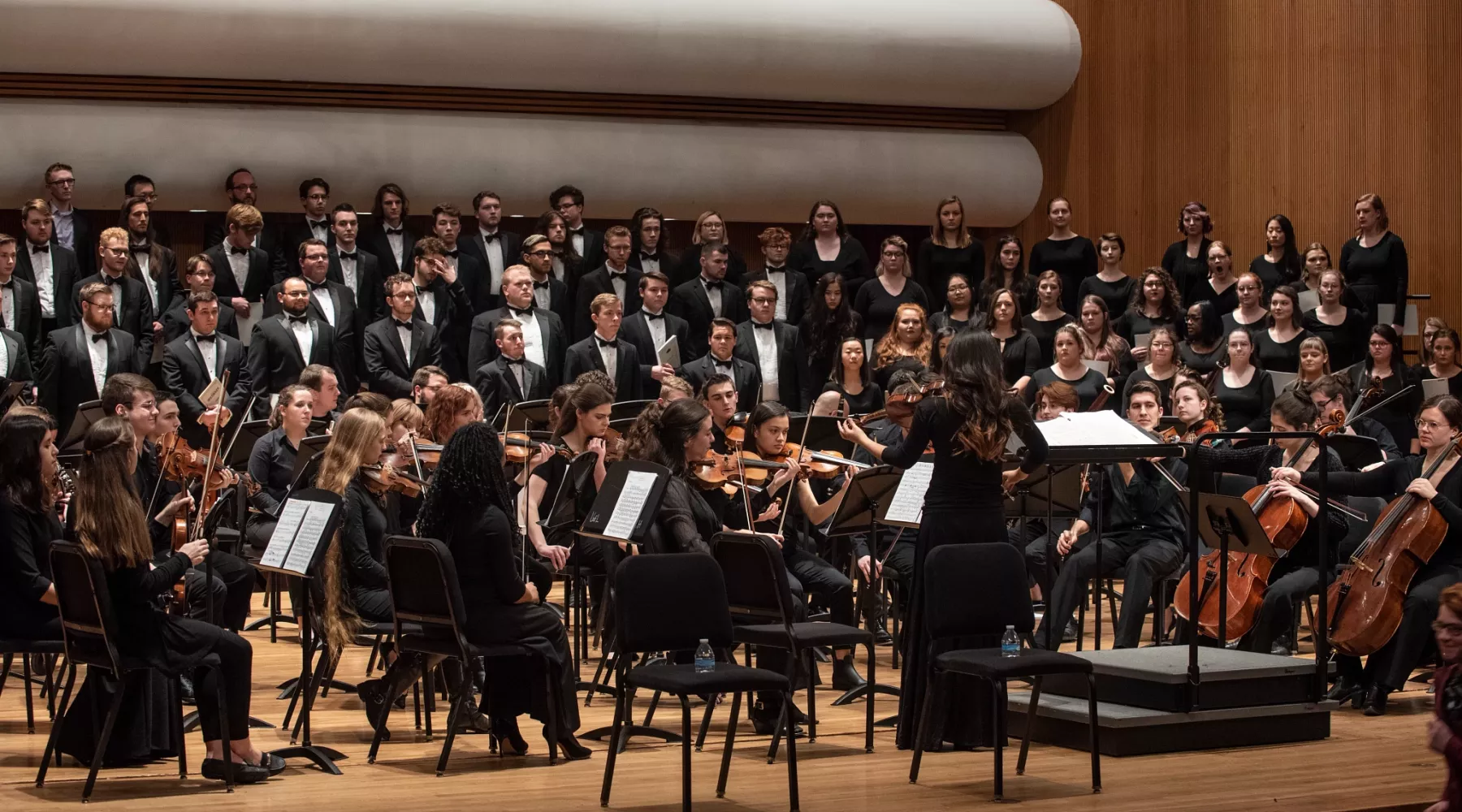 Musicians who played instruments and sang in a music symphony concert.