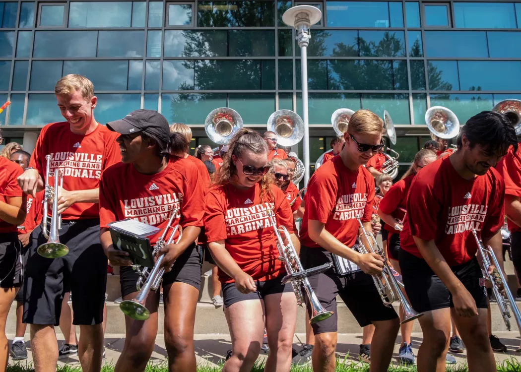UofL Cardinal Marching Band members performing at a picnic outside of Ekstrom Library