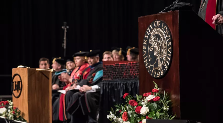 The podium at graduation with faculty in background