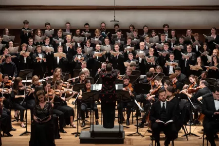 Students playing instruments and singing in a music symphony concert.